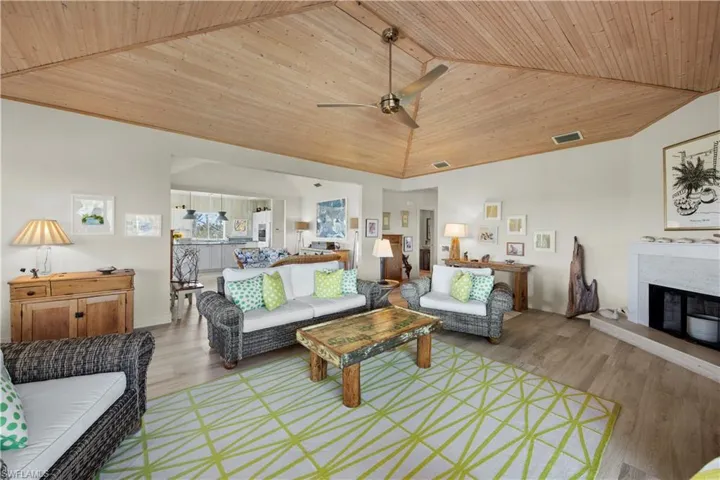Living room featuring ceiling fan, high vaulted ceiling, wooden ceiling, and light wood-type flooring