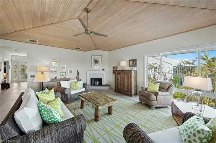 Living room with ceiling fan, vaulted ceiling, light hardwood / wood-style flooring, and wooden ceiling