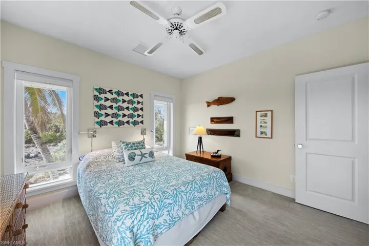 Carpeted bedroom featuring ceiling fan