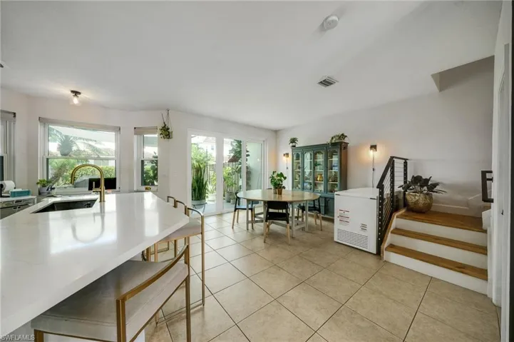 Kitchen featuring light stone countertops, plenty of natural light, sink, and light tile floors