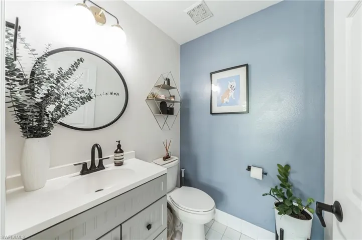 Bathroom with tile flooring, toilet, and vanity with extensive cabinet space