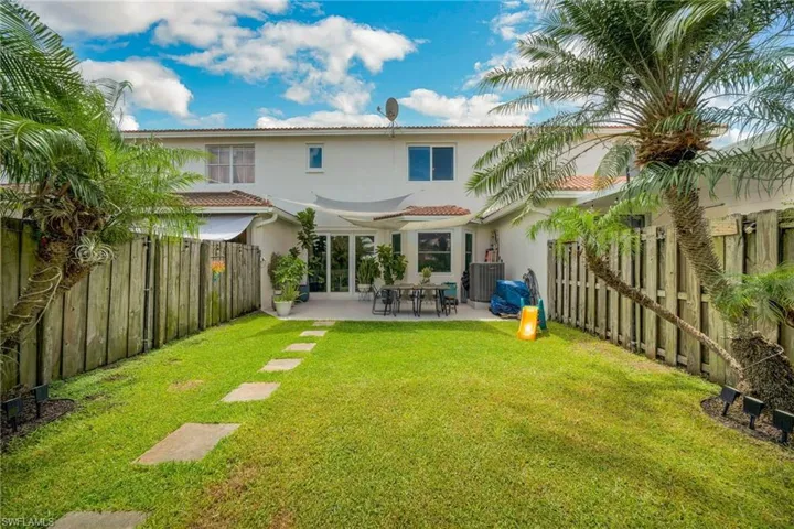 Back of house with a lawn and a patio area