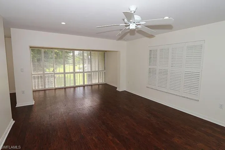 Empty room featuring ceiling fan, dark wood-style floors, and recessed lighting