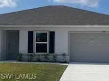 View of front of house with driveway, an attached garage, a front yard, and stucco siding