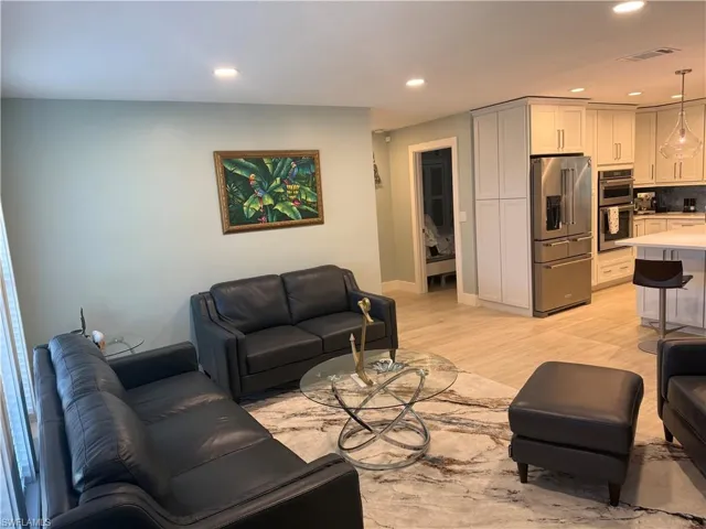 Living room with recessed lighting and light wood-style floors