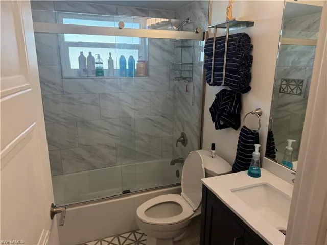 Bathroom featuring enclosed tub / shower combo and vanity