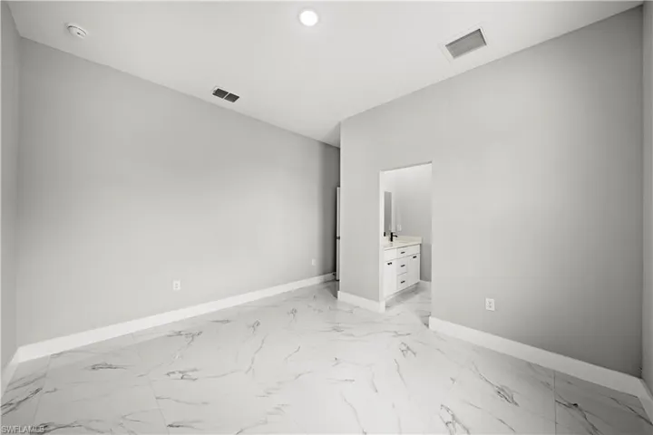 Empty room with light marble finish floors, a smoke detector, and recessed lighting