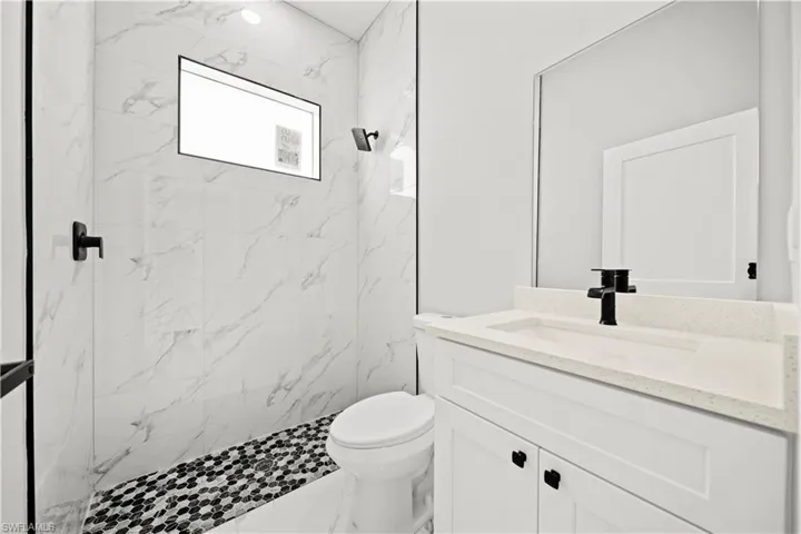 Full bathroom with vanity and a marble finish shower