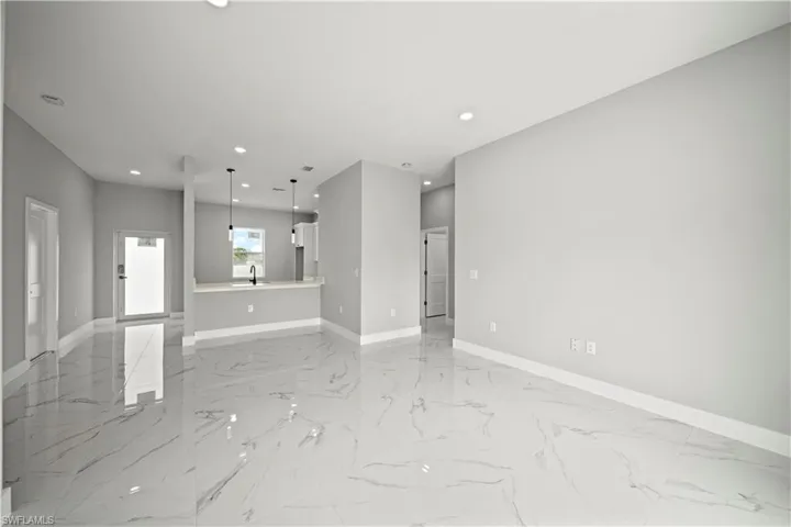 Unfurnished living room with light marble finish floors and recessed lighting