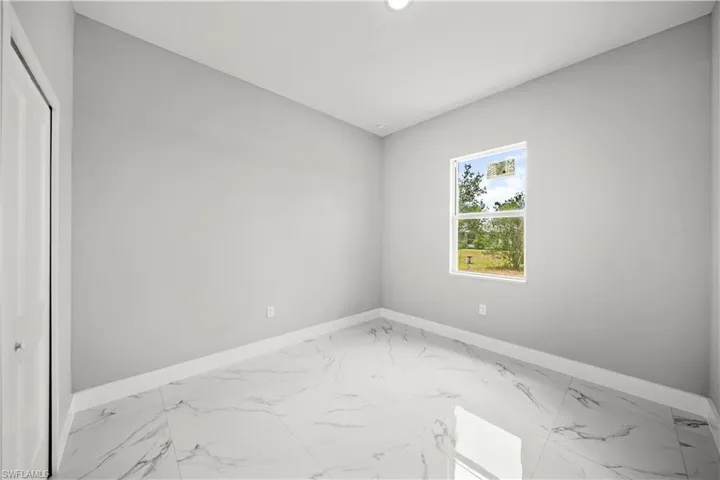 Spare room with baseboards and light marble finish floors