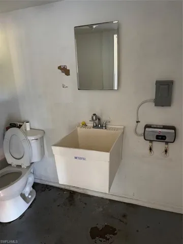Bathroom with toilet and concrete floors