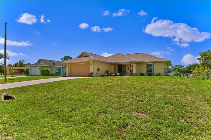 Ranch-style house featuring a garage and a front yard