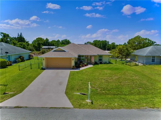 Ranch-style house with a garage and a front lawn