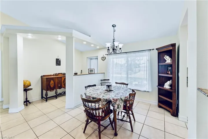 Dining area with a chandelier and light tile flooring