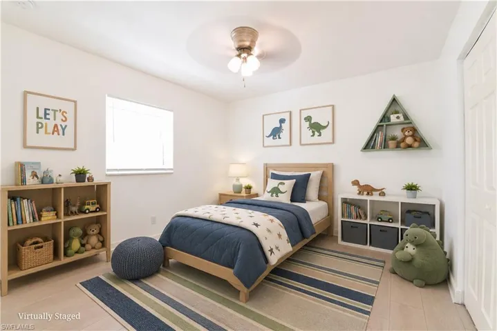 Light-filled room featuring a ceiling fan with light kit, a window with blinds, and light wood-finish flooring