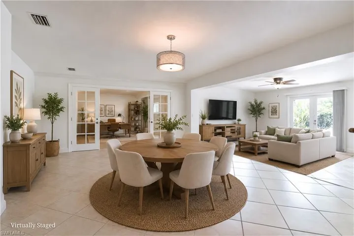 Open-concept living space featuring neutral tile flooring and white walls