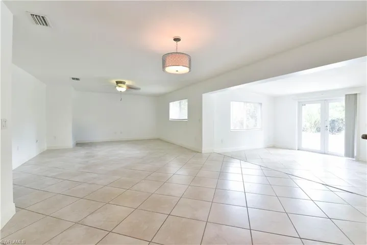 Spacious interior featuring tile flooring, multiple windows, and a ceiling fan
