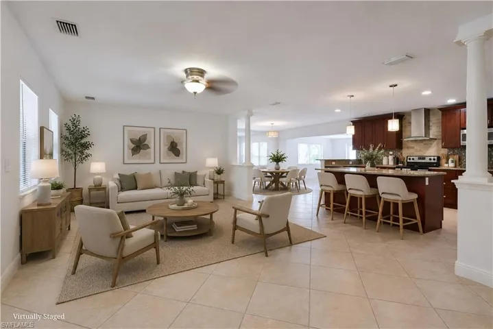 Open-concept living space featuring ceramic tile flooring, a ceiling fan, and multiple windows with blinds