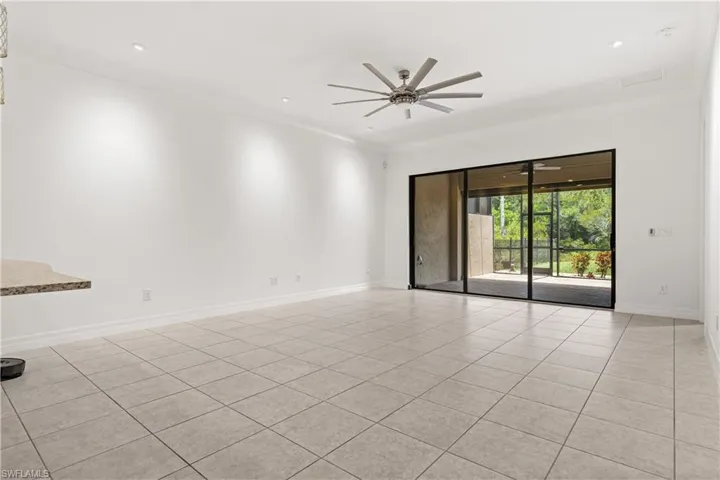Spacious interior featuring neutral tile flooring and recessed lighting