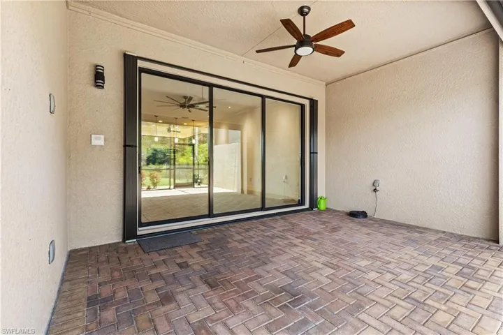 Covered outdoor patio featuring extensive paver flooring in a herringbone pattern