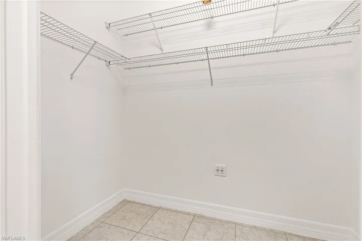 Walk-in closet featuring wire shelving, light-toned wall paint, and tiled flooring