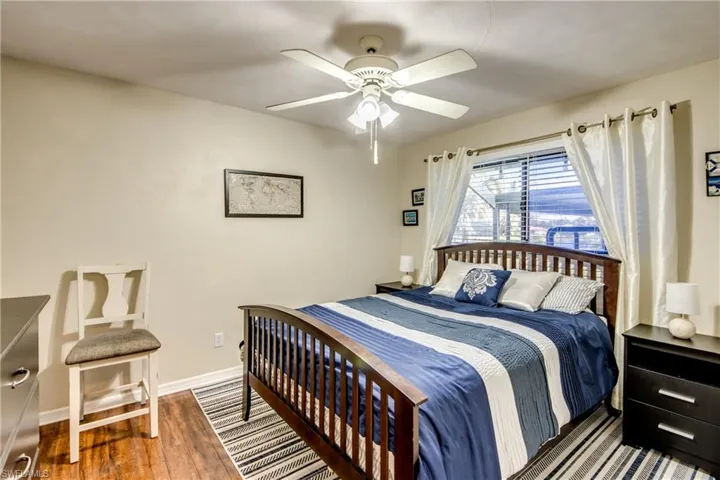 Guest bedroom with ceiling fan and wood-style flooring—great flex space in this Cape Coral home.