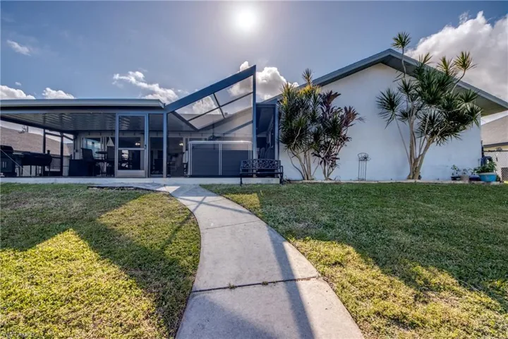 Rear exterior showing the home’s waterfront positioning and backyard access in Cape Coral.