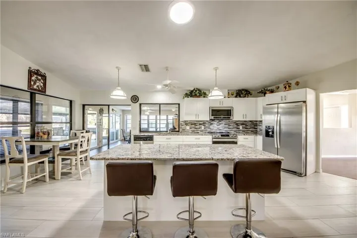Open kitchen with large island, bar seating, and ample cabinet storage.