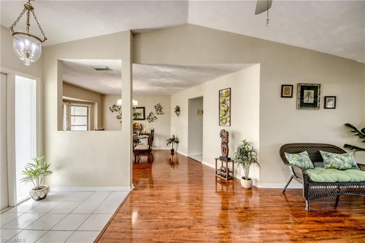 Spacious foyer featuring vaulted ceiling, wood-style flooring, and natural light.