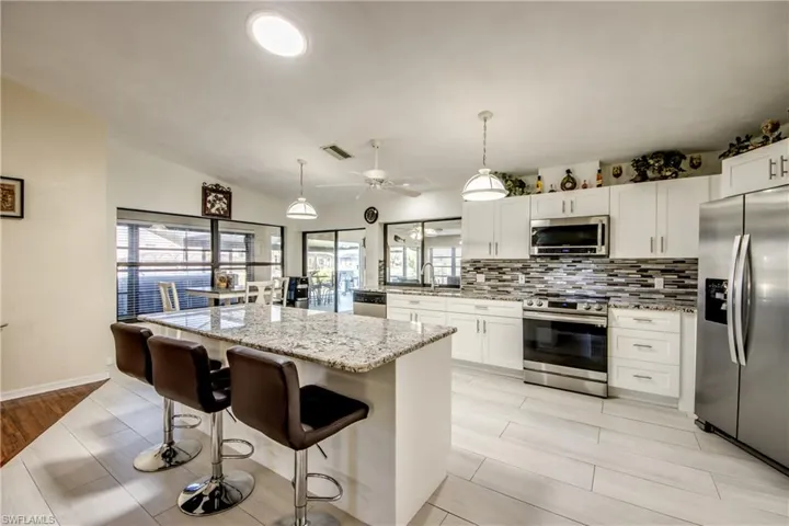 Kitchen view showcasing island workspace, modern lighting, and open-concept design.
