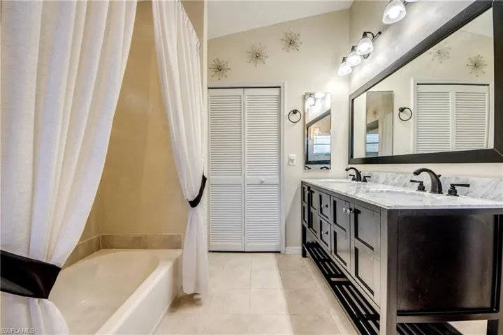 Bathroom with vanity storage and tub/shower combo—convenient layout for this Cape Coral Florida property.