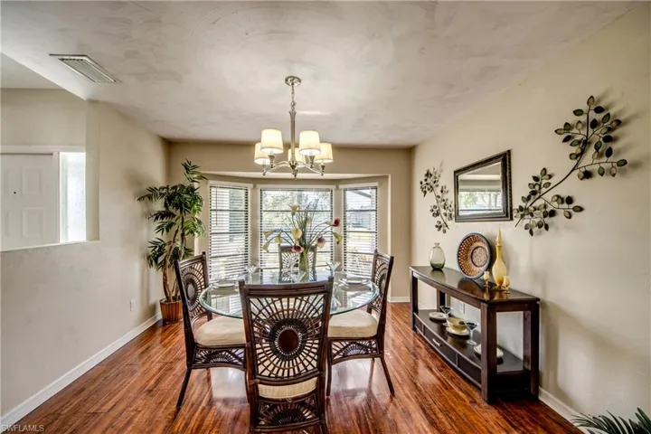 Dining room with dark wood finished floors and a chandelier