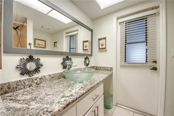 Bathroom with vanity, a shower, and light tile patterned floors