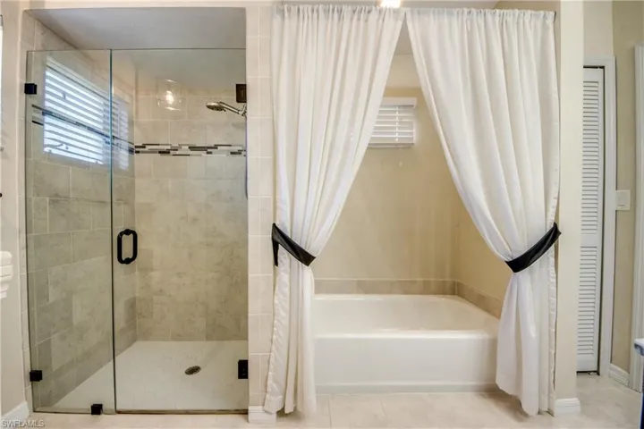 Full bathroom featuring a stall shower, a closet, a bathtub, and light tile patterned flooring