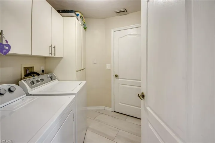 Dedicated laundry room featuring separate washer and dryer with storage space.