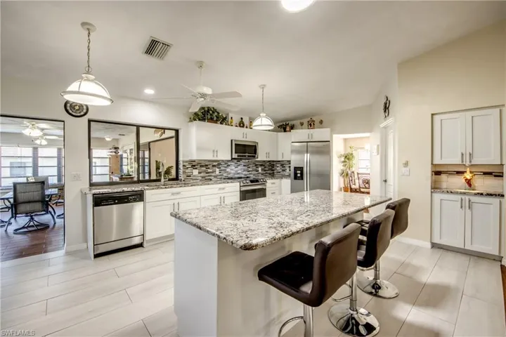 Kitchen with expansive countertops, bar seating, and seamless flow to dining space.