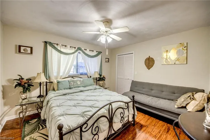 Bedroom with ceiling fan and wood-finished floors—perfect guest room or office in Cape Coral.
