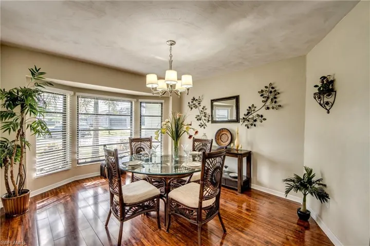 Dining area featuring dark wood-style flooring and a chandelier
