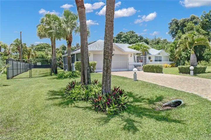 View of front of house featuring a garage and a front lawn