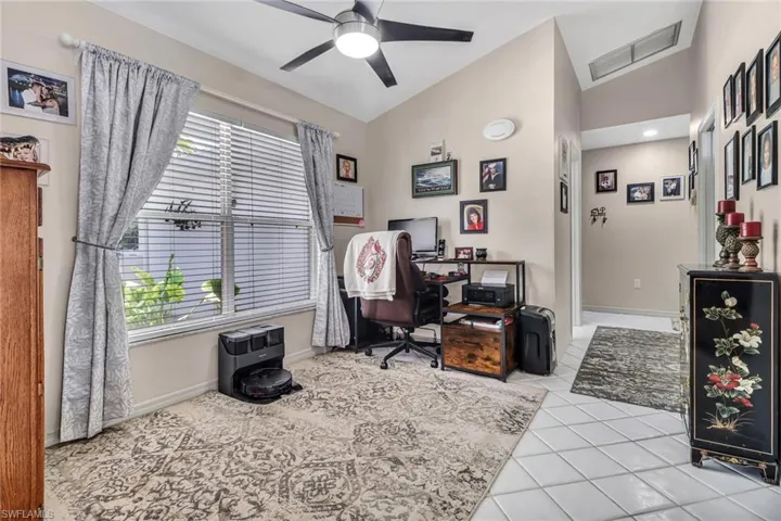 Office featuring lofted ceiling, ceiling fan, and light tile patterned flooring