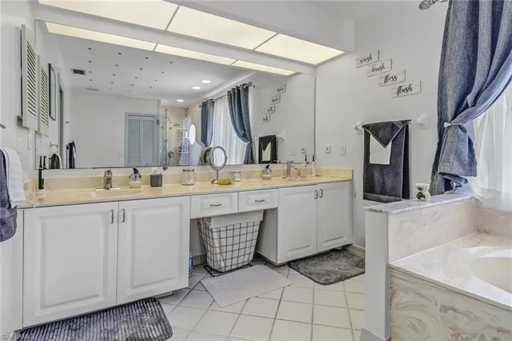 Bathroom with vanity, tile patterned floors, and separate shower and tub