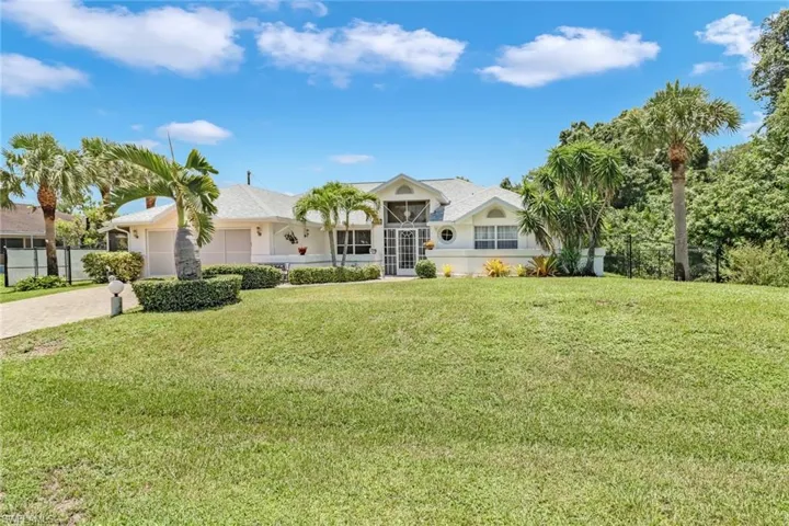 Ranch-style house featuring a garage and a front lawn