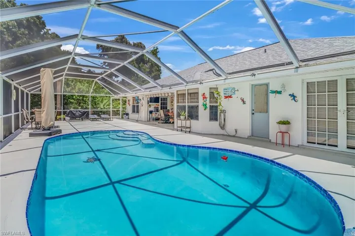 View of pool with a lanai and a patio