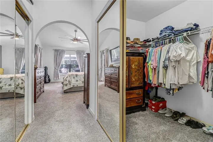 Spacious closet featuring ceiling fan and carpet floors