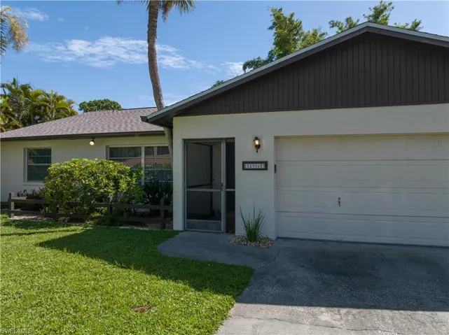 View of front facade with a garage and a front lawn