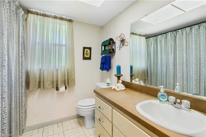 Bathroom featuring vanity, tile patterned floors, and toilet