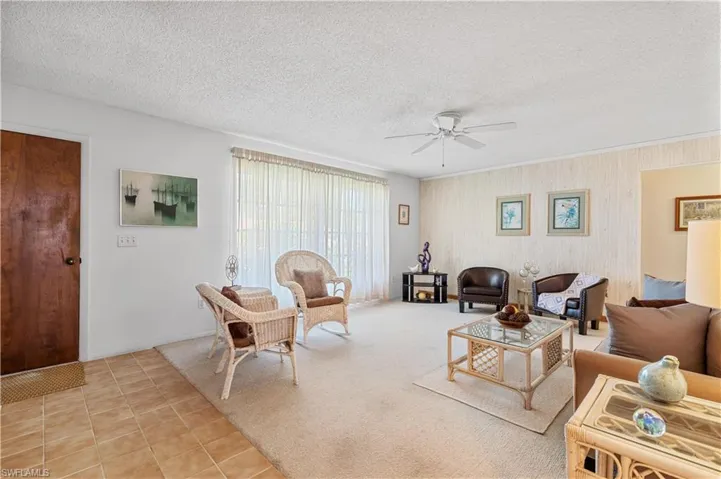 Tiled living room featuring a textured ceiling and ceiling fan