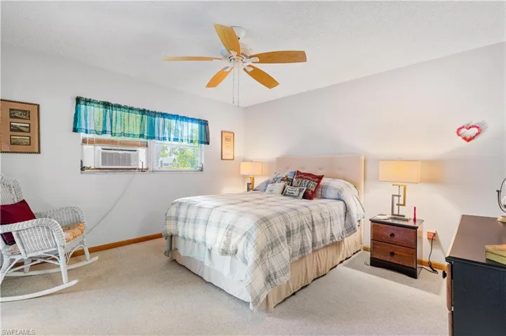 Bedroom featuring carpet flooring, a textured ceiling, ceiling fan, and cooling unit