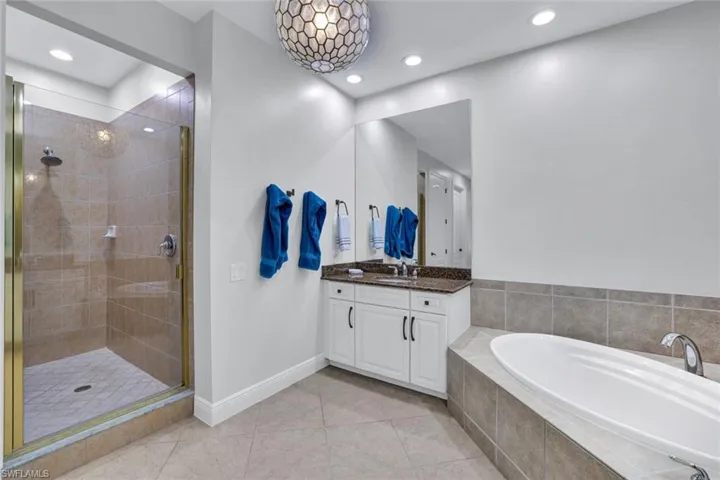 Full bathroom featuring vanity, a garden tub, a shower stall, tile patterned floors, and recessed lighting