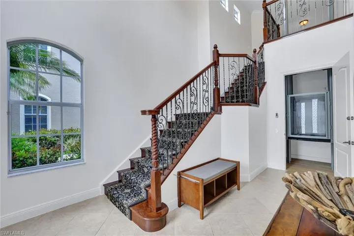 Stairs featuring plenty of natural light, tile patterned floors, and a towering ceiling